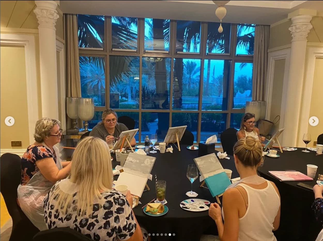 A guided sip and paint workshop table in a refined hospitality setting.